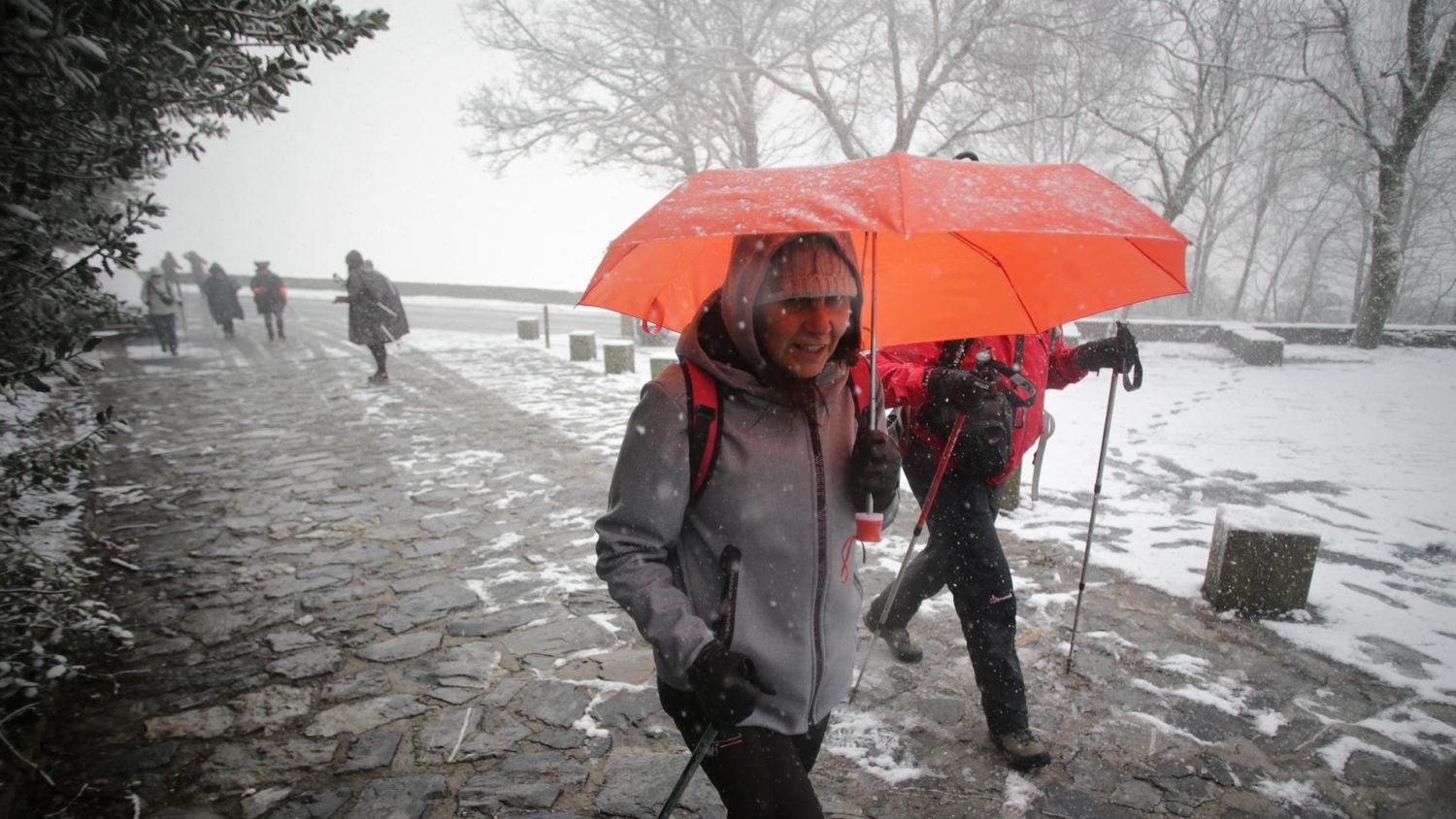 Una persona camina con bastones y ropa de abrigo mientras nieva en la parroquia de O Cebreiro, en Pedrafita do Cebreiro, Lugo, Galicia, (España)